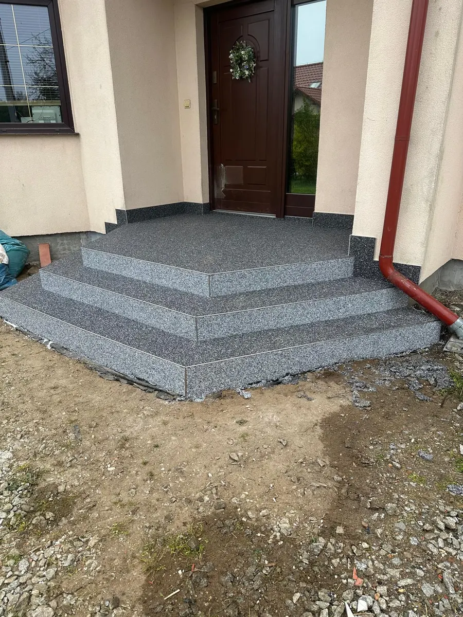 Schody i podest przy domu z kamienną nawierzchnią